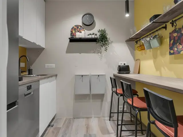 Shared kitchen with a bar and stools at NN Urban Guesthouse